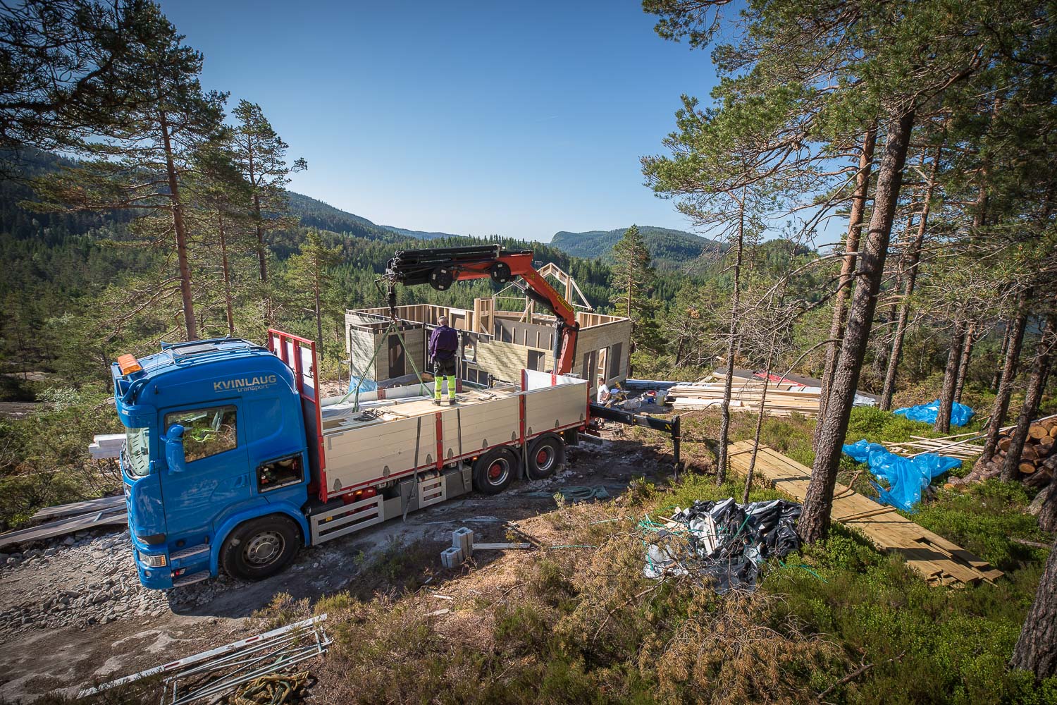 byggeplass på hyttetomt der det lastes materialer av lastebil